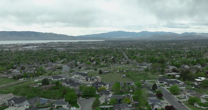 Pleasant Grove Utah County Utah USA suburban area with grid residential development near Utah Lake and Wasatch Front mountains within Basin and Range system, overcast sky,, drone forward flyover shot 