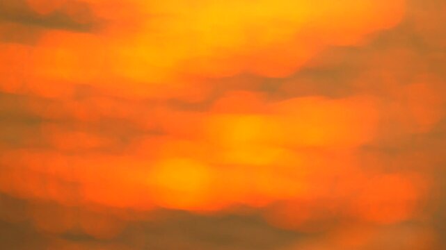 Bokeh sunset water reflection creating an abstract orange and golden light pattern on the surface for a peaceful atmospheric background