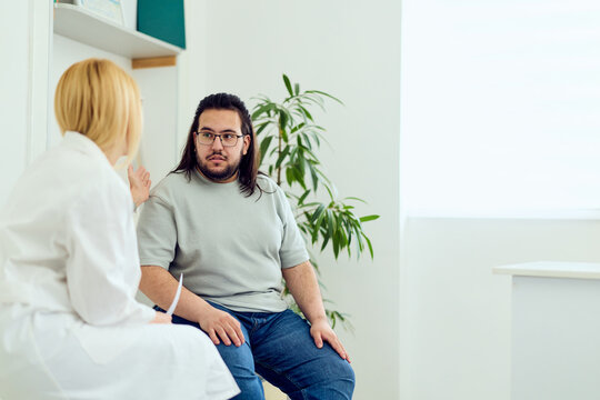Doctor Consultation With Male Patient In Medical Clinic Discussing Health and Weight Management