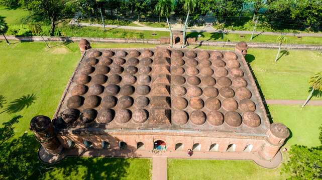 Aerial view of the Sixty Dome Mosque, a multi-domed mosque with its terracotta brickwork contrasting against the verdant lawn, Bagerhat, Khulna Division, Bangladesh.