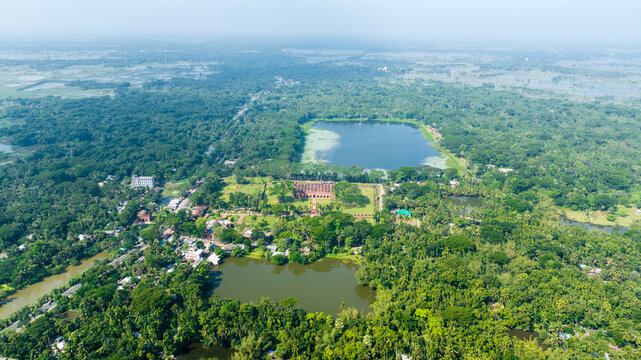 Aerial view of the Sixty Dome Mosque surrounded by lush green trees and serene ponds, Bagerhat, Khulna Division, Bangladesh.