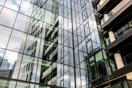 Modern corporate office facade in glass reflection with urban architecture pattern and sharp angles creating a clean financial background