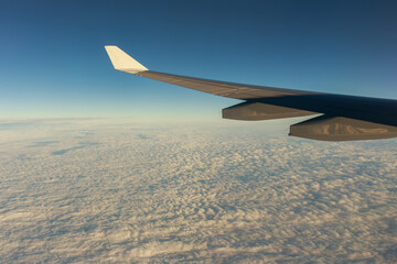 Airplane wing above a sea of clouds at golden hour, capturing travel, freedom, and the journey ahead, ideal for themes of travel, freedom, business trips, and global connectivity, window view © happycreator