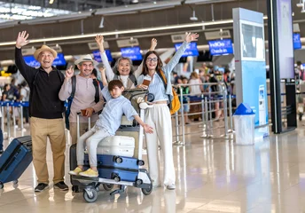 Asian multigenerational family at airport traveling with kids and grandparents, joyful moments of vacation, family holiday trip with luggage before flight, tour, friendly airline, hotel for families © Art_Photo