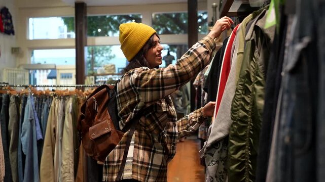 Young woman shopping for clothes in vintage thrift store