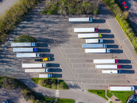 Aerial view of trucks neatly aligned in a parking lot with the green trees, Exeter, England, United Kingdom.