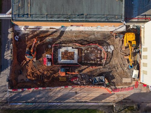 Aerial view of the new construction site, where heavy machinery works on the foundations of a building, Exeter, England, United Kingdom.