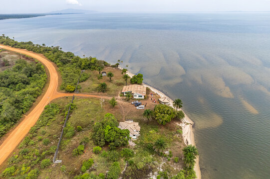 Aerial view of the coastline with a rustic road contrasting against the lush vegetation and the vast expanse of the ocean, Monrovia, Monrovia, Liberia.
