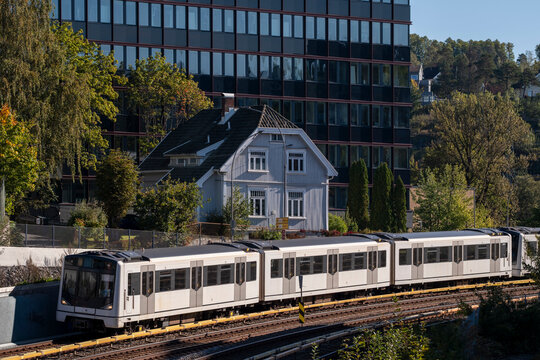 Elevated metro crosses bridge near Brynseng with residential cityscape in Oslo Norway as commuter transport moves through autumn greenery