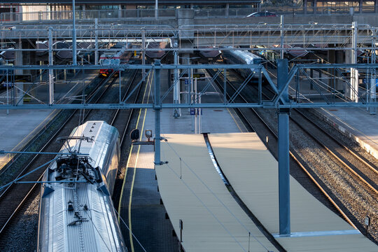 Modern train station terminal with overhead railway structure above tracks and platform in Oslo Norway serving daily commuter travel