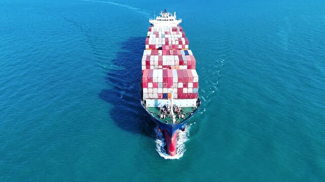large cargo container ship fully loaded with colorful containers sailing through the deep blue ocean. Global maritime trade, freight transport and logistics business.	
