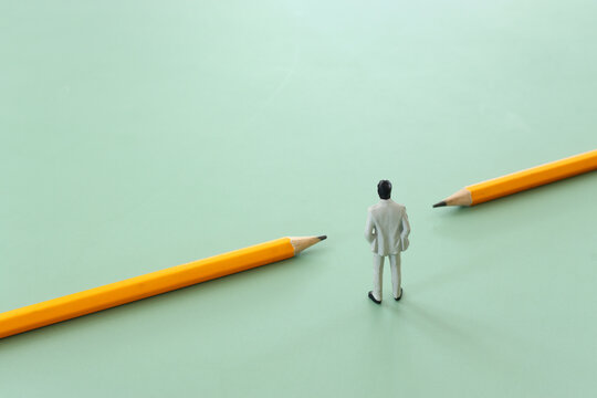 concept image of education as a barrier breaker. miniature figure crossing a barrier