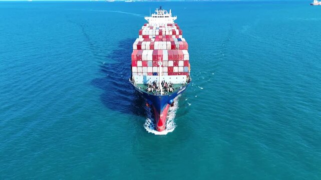 large cargo container ship fully loaded with colorful containers sailing through the deep blue ocean. Global maritime trade, freight transport and logistics business.	
