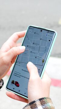 Woman's hands ordering ride sharing service on smartphone