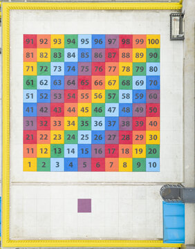Aerial view of a colorful numbered grid on an elementary school rooftop with vibrant square tiles and a yellow border Taiwan.