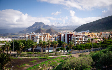 View of Los Cristianos, a popular coastal town in Tenerife, Canary Islands. The image shows a vibrant seaside city with beaches, harbor, and surrounding mountains along the Atlantic Ocean. This scenic © Pavel Kašák