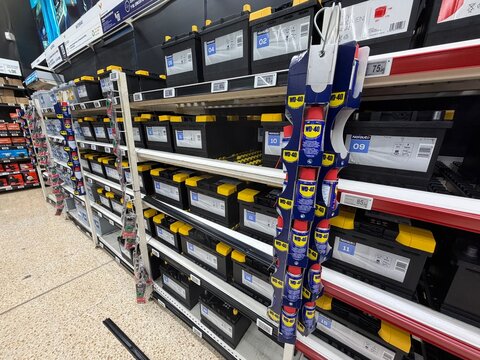 Mallorca, spain, april 14, 2026 automotive parts store shelves showcasing norauto car batteries and a prominent wd 40 spray display