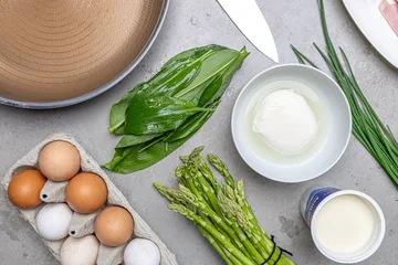 Cooking an italian frittata with mozarella, asparagus, eggs, onions, tomatoes and fresh herbs in spring time at home in the kitchen © mmphoto