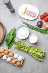 Cooking an italian frittata with mozarella, asparagus, eggs, onions, tomatoes and fresh herbs in spring time at home in the kitchen © mmphoto