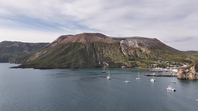 Aerial drone flying towards active volcanic crater on Vulcano island with dramatic terrain and textures.