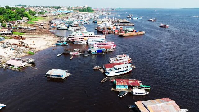Manaus City Harbour in Brazil. View of traditional Amazon riverboats, ferries, and floating houses along the shore of the Rio Negro, cinematic aerial video