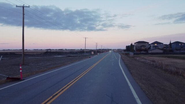 Car on a rural road flyover drone overhead shot evening overcast