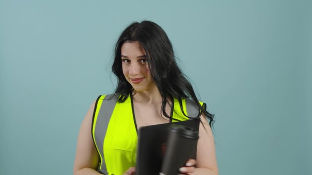 Portrait of a female worker in a signal vest holding a folder