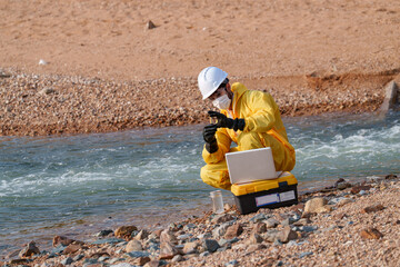 Scientist works at riverbank on environmental study during sunny day in natural setting