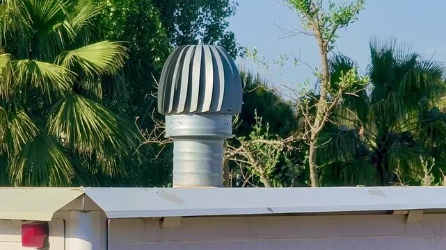 Turbina de ventilaci&oacute;n girando en chimenea expulsando aire en tejado