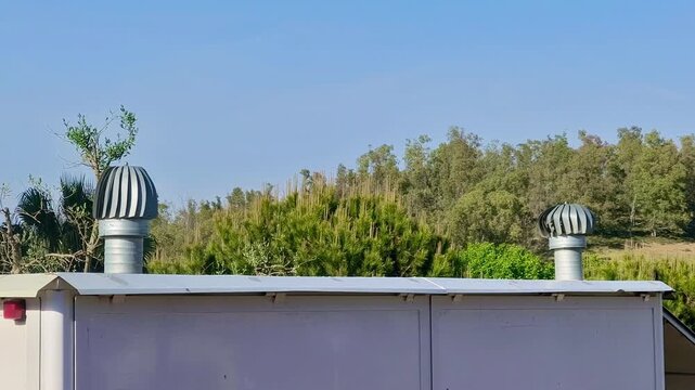 Turbina de ventilaci&oacute;n girando en chimenea expulsando aire en tejado