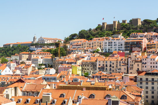 Lisbon, Portugal - 15 April 2024: View over the city center of Lisbon with historic fortress Castelo de Sao Jorge on a hill and houses with colorful facades underneath