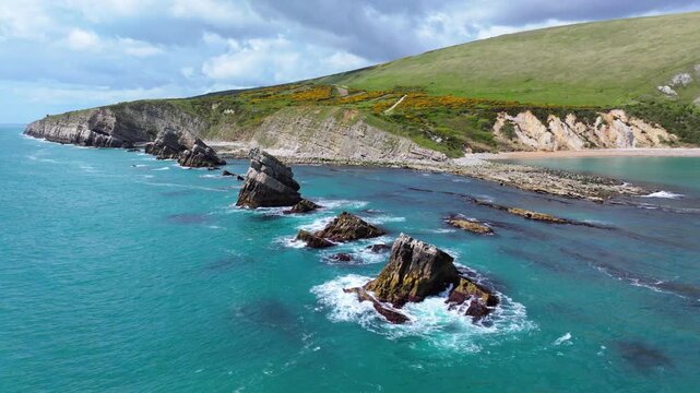 Tracking aerial shot of Jurassic coast and sea rocks at Mupe Bay in Dorset