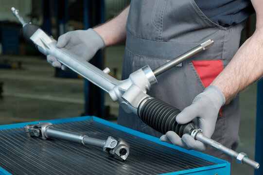 Repair of rack-and-pinion steering gear in a car service station.An auto mechanic prepares the installation of a new steering rack and a new steering driveshaft.