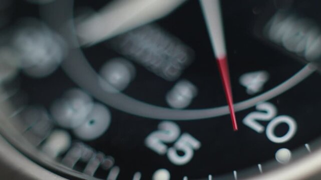 Macro close up of an automatic mechanical field watch with moving arms
