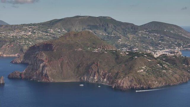 Drone flying left along Lipari coastline using telephoto lens showing compressed landscape and terrain.