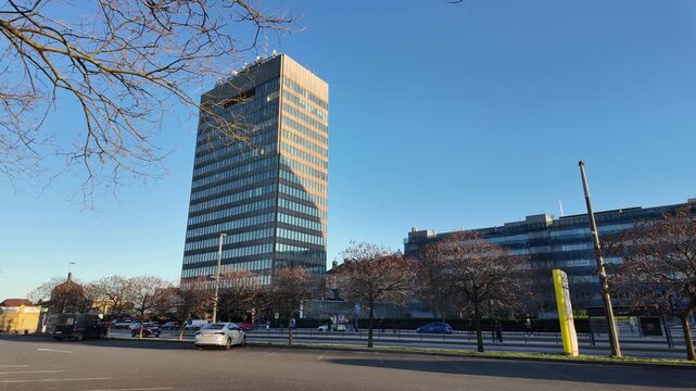 Prague, Czech Republic - March 13, 2026 - Zizkov. Modern glass skyscraper and urban street scene with cars and trees