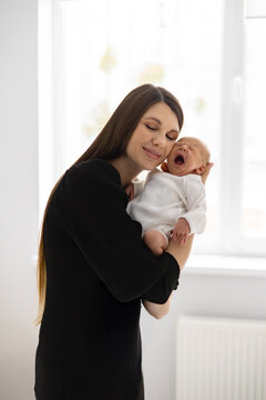 A tender moment between a mother and her newborn baby, captured in a soft, natural light setting
