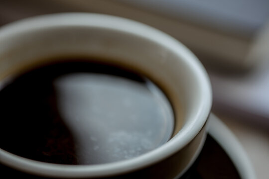 Aromatic cappuccino in mug with rising steam, cozy coffee break moment, rich espresso tones, peaceful mood, morning refreshment in modern caf&eacute; setting.
