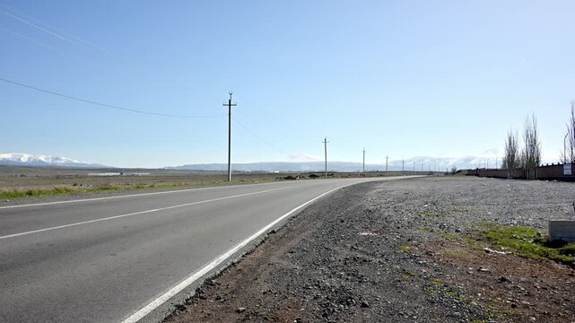 White van drives along paved road under clear blue sky