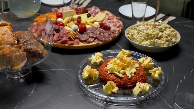Christmas Dinner Table with Steak Tartare, Cold Cuts, Cheese Platter and Salad