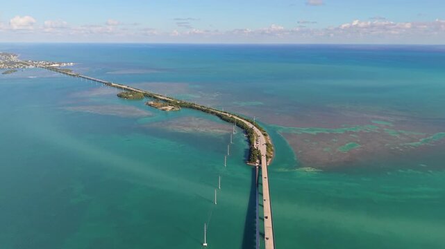 Cinematic aerial drone footage capturing the parallel spans of the Seven Mile Bridge and historic railway ruins over turquoise tropical waters.