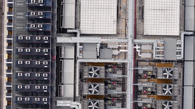 Aerial view captures industrial rooftop systems. Fans and ducts dominate the mechanical infrastructure
