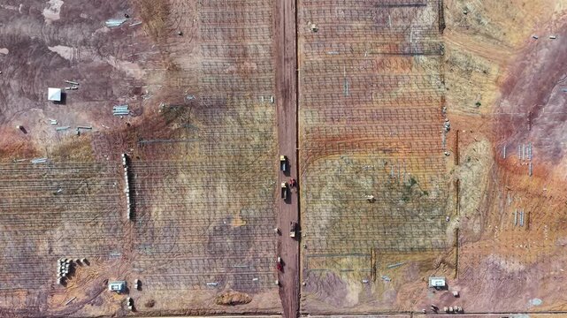Aerial drone view of solar farm under construction with racking and heavy equipment
