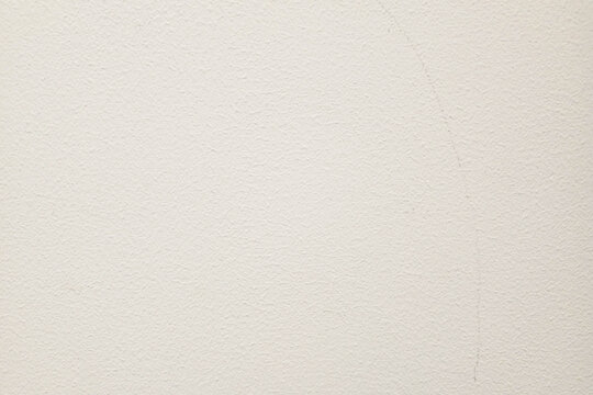 Off-white textured wall background with a subtle, rough surface finish