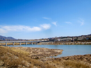 Fototapeta premium Scenic river view with bridge and clear blue sky