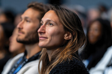 Fototapeta premium A focused audience member enjoying an engaging event, capturing emotions and connections between individuals in a stunning photographic moment of attentiveness and engagement.