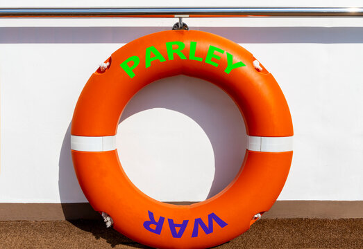 Parley instead war symbol. Concept words Parley and War on beautiful orange lifebuoy. Beautiful white ship board background. Social and parley instead war concept. Copy space.