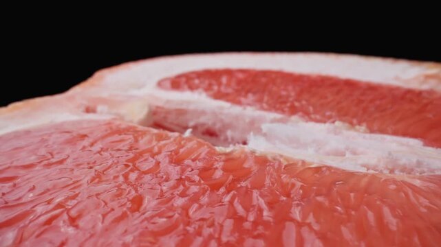 Half of juicy grapefruit. Dolly slider shot with macro lens. Organic healthy food concept. Tasty citrus fruit. Close-up in 4K, UHD
