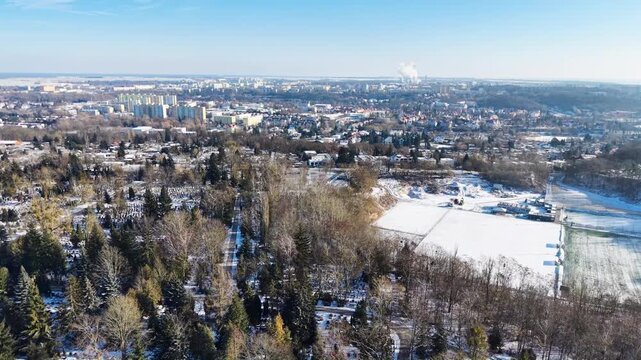 Aerial fly over view of Żwirowa Street Municipal Cemetery with Piaski and Manhatan residential areas in the background. Gorz&oacute;w Wielkopolski in winter. Poland