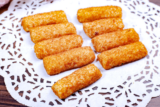 Crispy Golden Brown Fried Rissole Rolls on a White Lace Doily.
